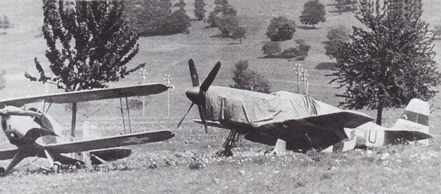 Zusammen mit einer Bücker Bü-131 Jungmann der Fliegertruppe wartet die Mustang auf den Abtransport nach Dübendorf. Die Abdeckblache stammt von einer Morane D-3801.