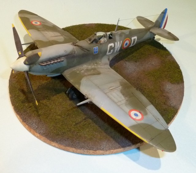 Die Dioramenplatte entstand aus Weißleim-Sand-Gemisch mit erdfarbenen Pigmenten und Streugras. Dezentes Drybrushing mit den Farbtönen der Flugzeugtarnung zum Abblenden des Dioramas.
