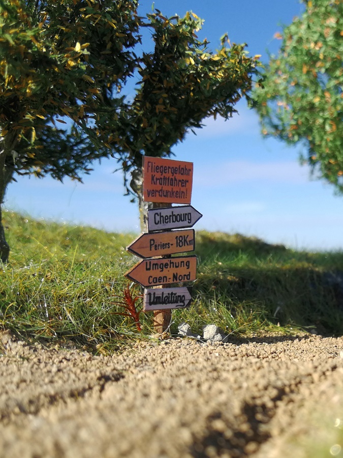 Die Wegweiser kommen aus dem Farbdrucker, wurden auf eine dünne Holzfurnierplatte geklebt und ausgeschnitten