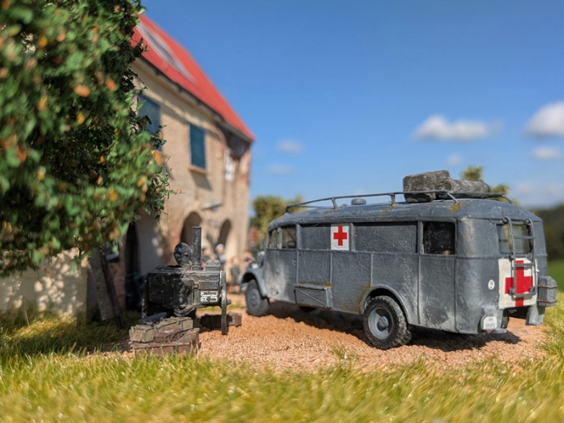 Ein Opel Blitz Omnibus W39 als Krankentransporter vor einem Feldkrankenhaus