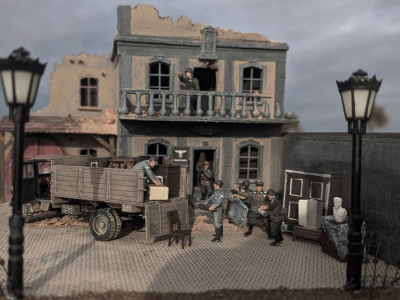 Während der Soldat auf dem Balkon die Front im Blick behält, versuchen die Soldaten noch zu retten, was noch zu retten ist - auch wenn die Kommandantur schon einige Bomben- und Granattreffer einstecken musste